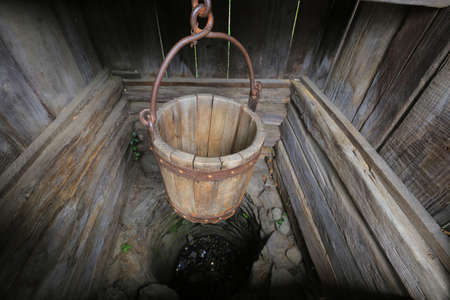 Old wooden bucket in a well close-upの写真素材