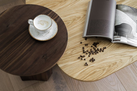 White cup of cappuccino with coffee beans on a brown wooden table, top viewの写真素材