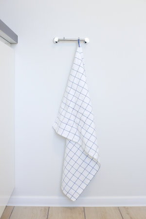 White kitchen towel hanging on a hanger in the kitchenの写真素材