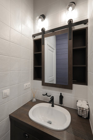 Faucet with ceramic sink and mirror in the bathroom interiorの写真素材