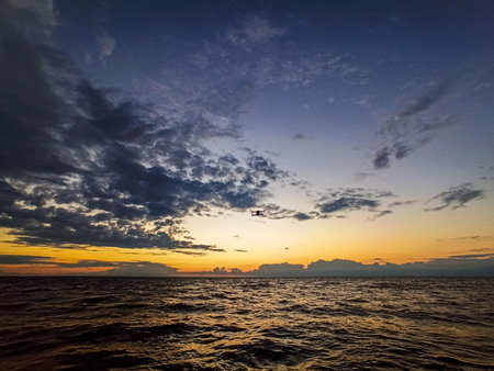 Drone flying on the sea at beautiful sunsetの写真素材