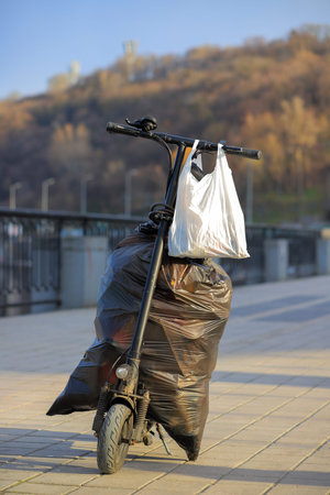 Bags of garbage on an electric scooter on a street in the cityの写真素材