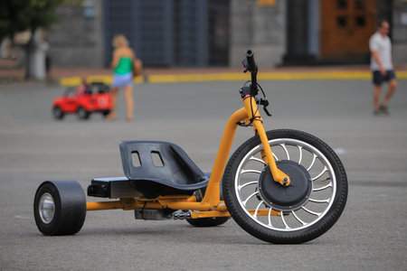 Tricycle children's electric bike on the street in cityの写真素材