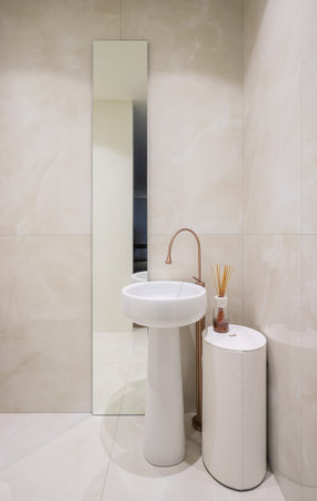 White ceramic sink, faucet and mirror in the bathroom interior