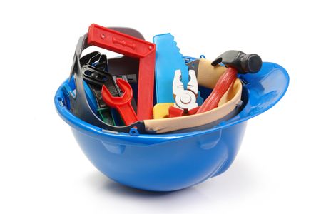 Set of plastic toy tools in blue helmet over white backgroundの写真素材