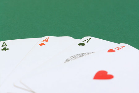 Hand of four aces on green table