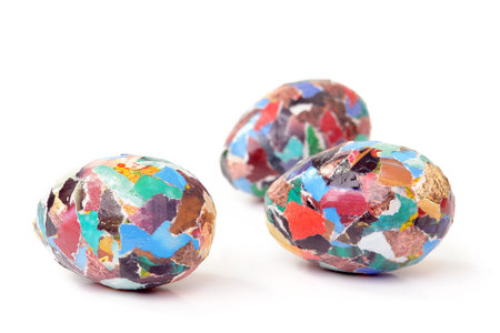 Three paper collage eggs over white background