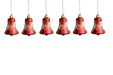 Row of red christmas bell decorations hanging on strings over white backgroundの写真素材