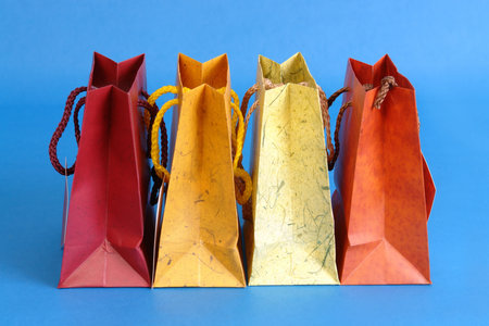 Row of four colorful paper shopping bags