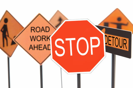 Closeup of stop sign with various american road construction signs in the background