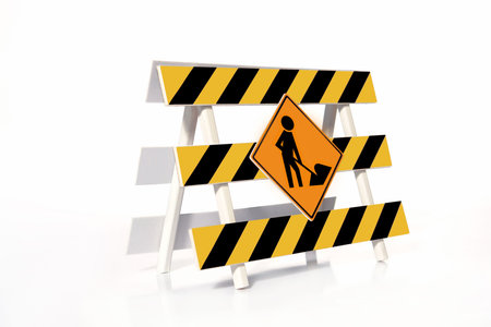 Yellow and black striped road construction barrier with Worker roadsign over white background