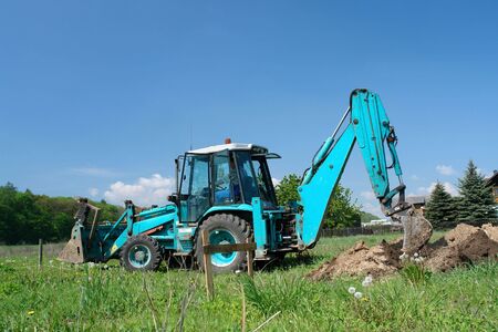 Backhoe loader working in the fieldの写真素材