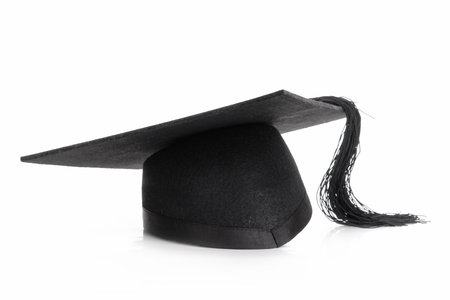 Black graduation cap shot over white backgroundの写真素材