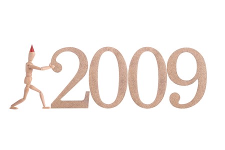 Wooden dummy with red cone hat pushing 2009 year digits - isolated on whiteの写真素材