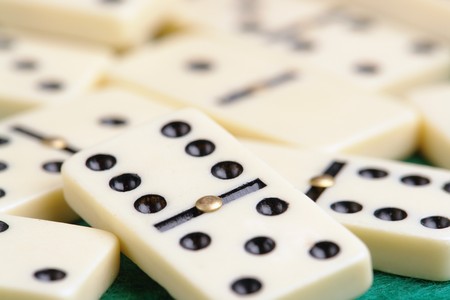 Pile of domino pieces shot on green tablecloth fabricの写真素材