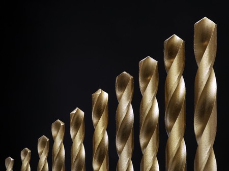 Set of ten golden drills for metal drilling over black backgroundの写真素材