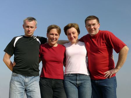 Portrait of four young friends posing over blue skyの写真素材