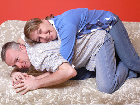 Young happy couple having fun posing on sofa