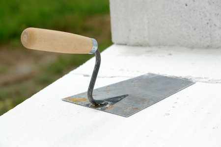Closeup of mason's trowel on white hollow brickの写真素材