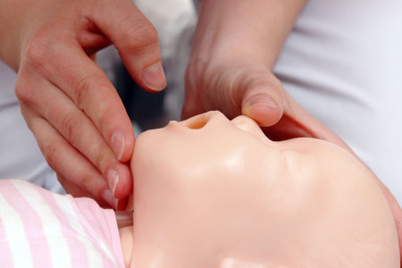 Infant dummy first aid demonstration series - First aid instructor showing how to position infant...