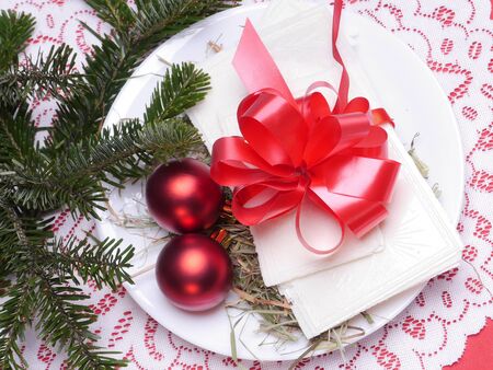 Traditional Christmas Eve white wafer on a plate with red cockadeの写真素材