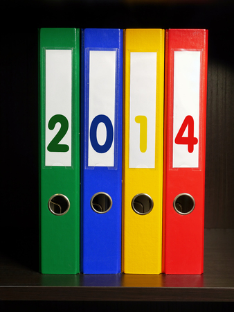 Four color binders with New Year 2014 digits placed on bookshelfの写真素材
