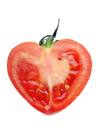 Red tomato half in the shape of heart shot on white backgroundの写真素材