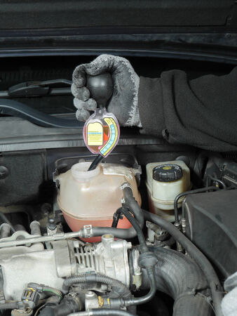Auto mechanic performing antifreeze coolant freeze-up protection test using a testerの写真素材