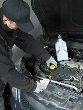 Auto mechanic unscrewing oil filler capの写真素材