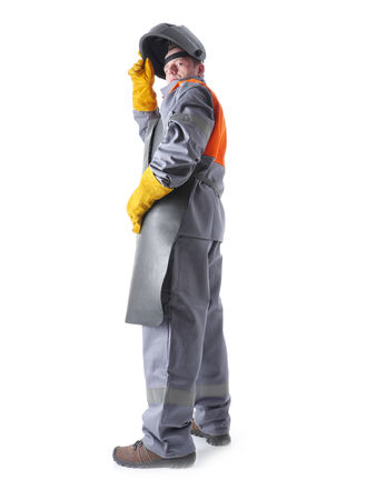 Portrait of welder wearing protective welding black leather apron and welding hood standing over whiteの写真素材