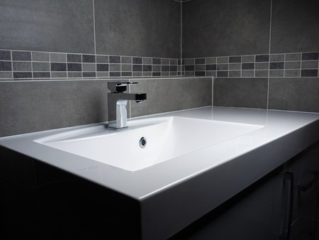 Modern bathroom washbasin with chrome faucet and gray tiling Modern bathroom washbasin with chrome faucet and gray tiling
