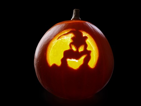 Jack-o-lantern pumpkin backlit over black backgroundの写真素材