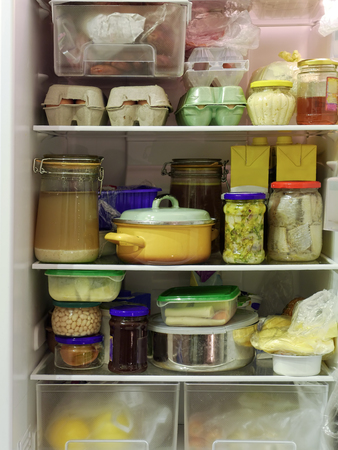 Refrigerator inside full of assorted food ingredients, fruit, vegetables, meat and dairy productsの写真素材
