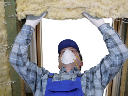 Worker thermally insulating a house attic using mineral woolの写真素材