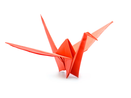 Traditional Japanese origami crane made from red paper over white backgroundの写真素材
