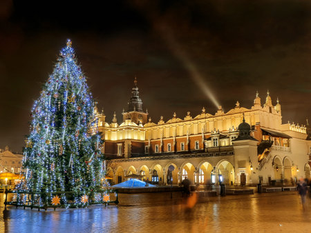 Giant christmas tree illuminated at night standing next to historical Cloth Hall on the Main Market Square in Krakow, Polandのeditorial素材