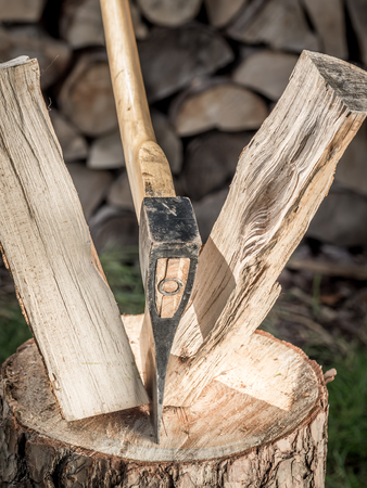 Closeup of axe splitting log on chopping blockの写真素材