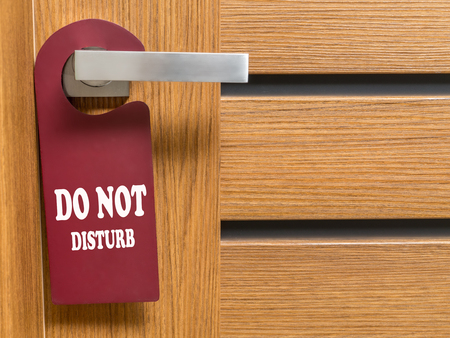 Do Not Disturb door hanger hanging on hotel room door handleの写真素材