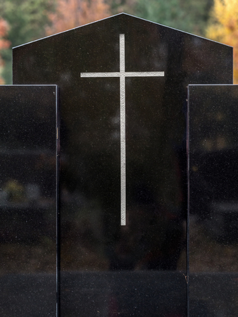 Closeup of black granite tombstone with white crossの写真素材