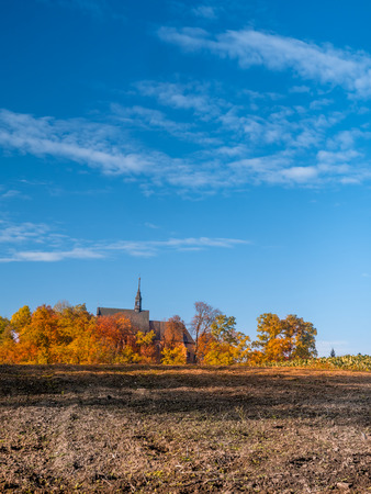 Countryside old catholic church surrounded by trees in fall colorsの写真素材