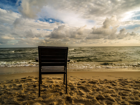 Wooden armchair placed on the beach with the view to the seaの写真素材