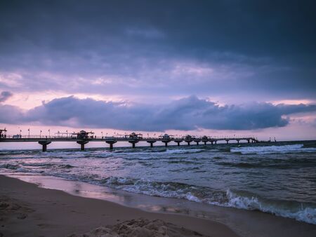 Miedzyzdroje Pier against dramatic sunset sky, The pier is 395 metres long, stretching out into the Baltic Sea from the beach in Miedzyzdroje, West Pomeranian Voivodeship, Polandの写真素材