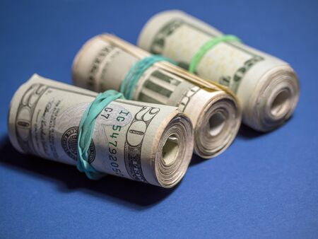 Rolls of American dollar bills on blue backgroundの写真素材
