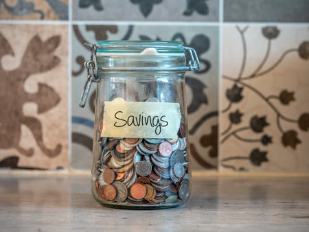Small change savings in glass jar on kitchen tabletopの写真素材