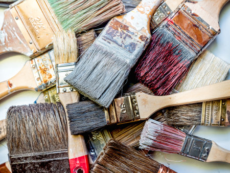 Pile of used and dried paint brushes shot from above