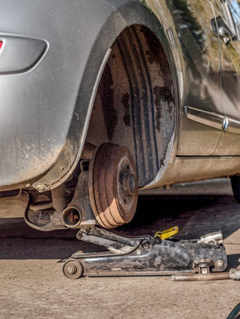 Passenger vehicle on lift with tire being changed
