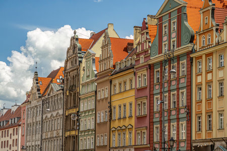 Vividly painted historical buildings with distinctive facades of Old Town Wroclaw, showcasing European architectural styles in a charming urban setting under a blue sky with clouds, Wroclaw, Polandの写真素材