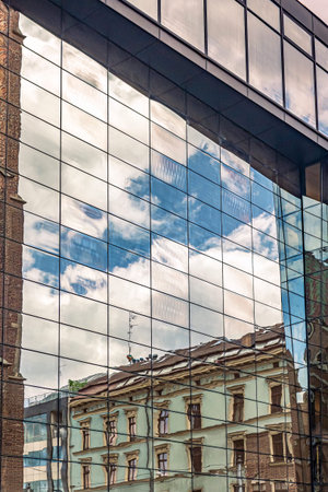 Urban architecture where a contemporary glass building reflects the image of historical structures...
