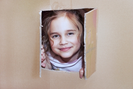 Little girl inside cardboard playhouseの写真素材