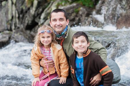 Family sitting close to mountain streamの写真素材